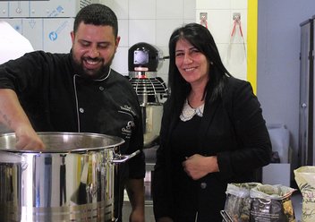 Zwei Helfer stehen hinter einem großen Topf in einer Suppenküche. Foto: ELCJHL