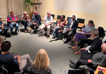 Rund zwanzig Personen sitzen zur Diskussionsrunde in einem Stuhlkreis.