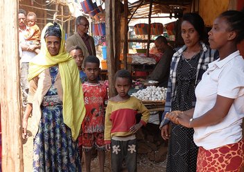 Zwei Frauen verkaufen ihre Produkte auf einem Markt.