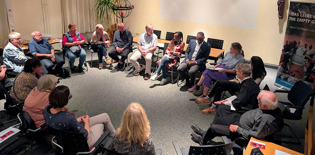 Rund zwanzig Personen sitzen zur Diskussionsrunde in einem Stuhlkreis.